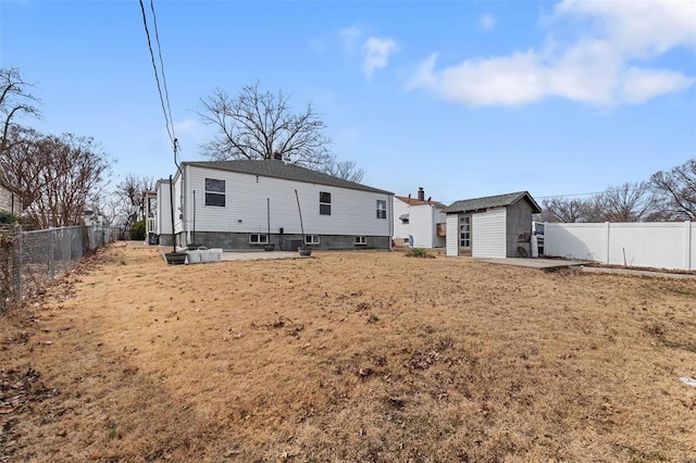 rear view of property with an outdoor structure and a fenced backyard