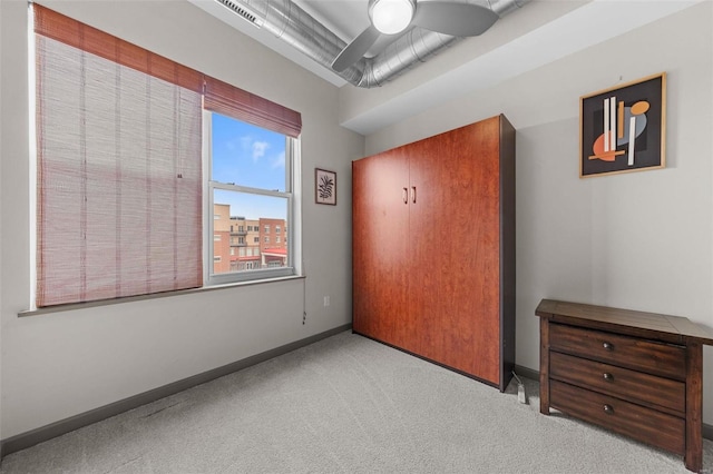 unfurnished bedroom with a ceiling fan, carpet flooring, visible vents, and baseboards