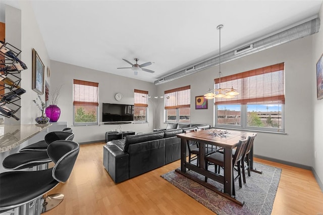 dining room with a wealth of natural light, light wood-style flooring, visible vents, and baseboards