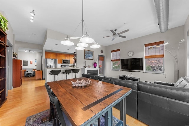 dining area featuring ceiling fan and light wood finished floors