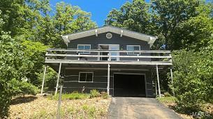 view of front facade featuring a garage, driveway, and a deck