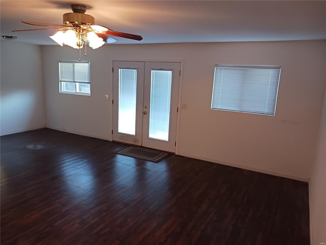 spare room with dark wood finished floors, a ceiling fan, and french doors