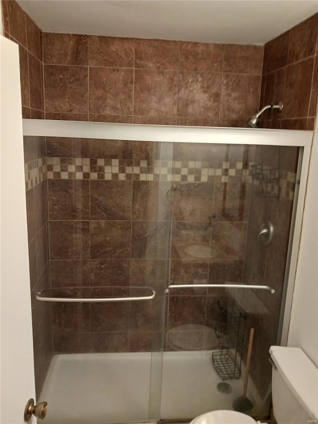 bathroom with a shower stall and toilet