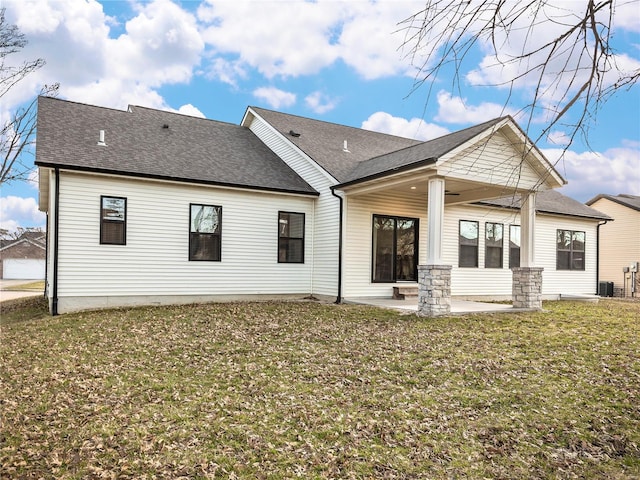 rear view of house featuring a patio area, central air condition unit, a lawn, and roof with shingles