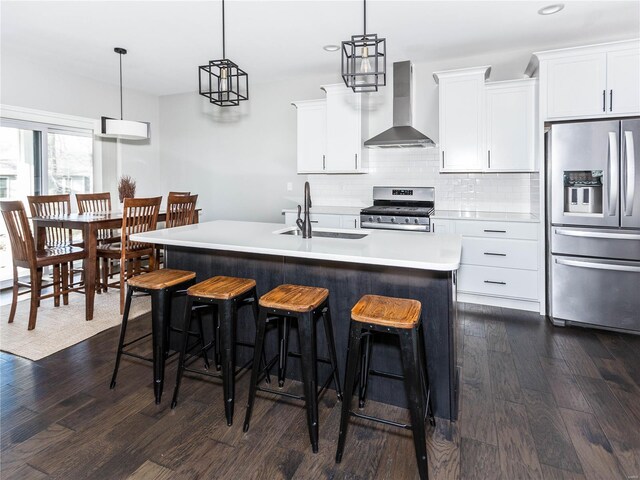 kitchen featuring a sink, stainless steel appliances, dark wood-style floors, and wall chimney exhaust hood