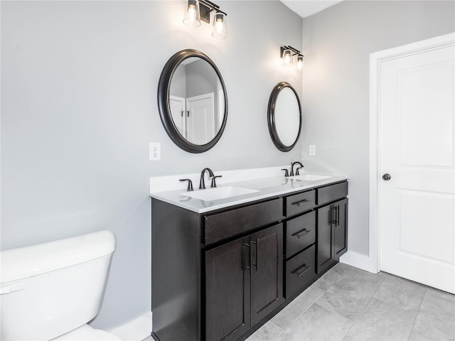 full bath featuring a sink, toilet, and double vanity