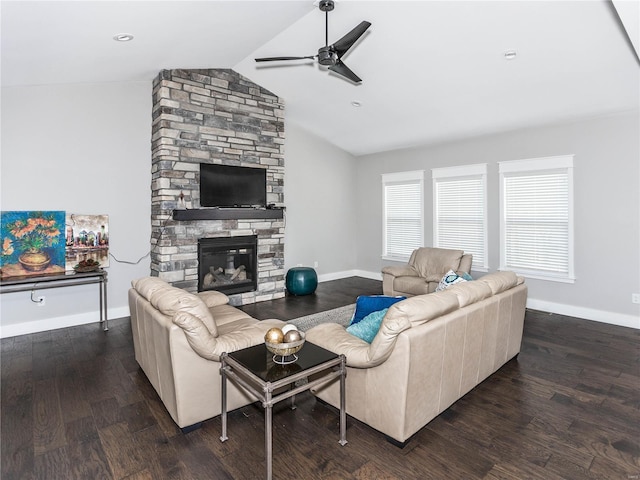 living room with baseboards, vaulted ceiling, a stone fireplace, wood finished floors, and a ceiling fan