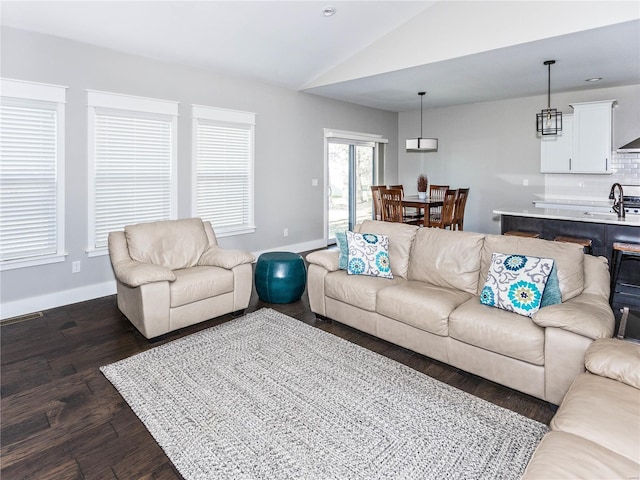 living room featuring vaulted ceiling, baseboards, and dark wood-type flooring