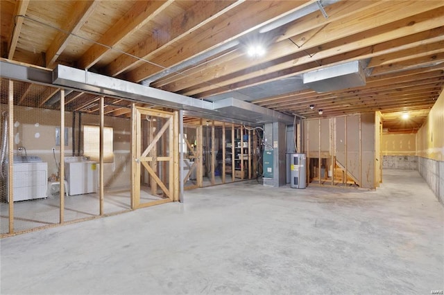 unfinished basement featuring washer / clothes dryer and hybrid water heater