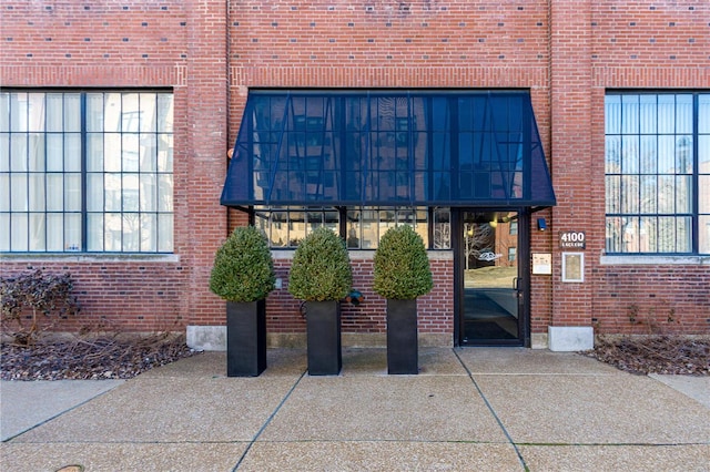 view of exterior entry featuring brick siding