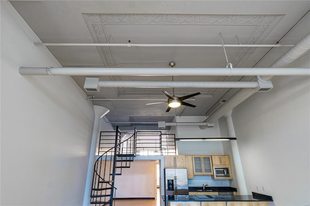 interior space featuring stairs, a high ceiling, and a ceiling fan