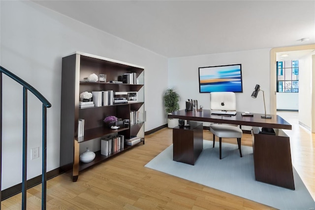 home office featuring baseboards and wood finished floors