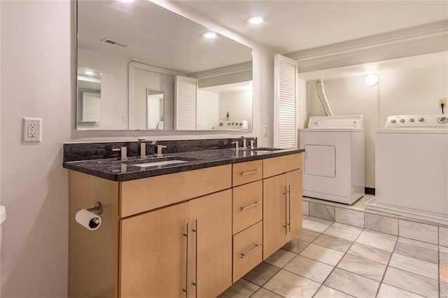 bathroom featuring double vanity, visible vents, a sink, and washing machine and clothes dryer