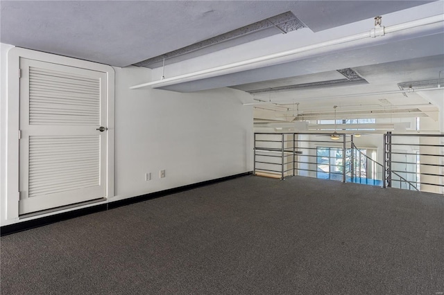 carpeted empty room featuring baseboards