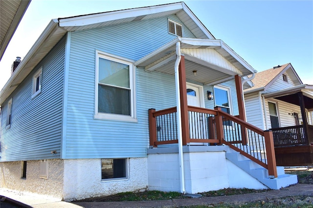 view of side of home with stairs and covered porch