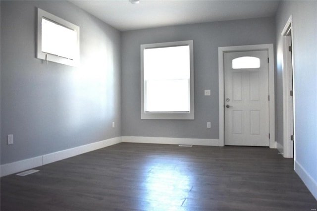 entrance foyer with dark wood-type flooring and baseboards