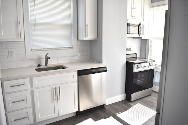 kitchen with white cabinetry, appliances with stainless steel finishes, light countertops, and a sink