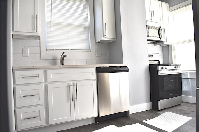 kitchen with stainless steel appliances, light countertops, a sink, and dark wood-type flooring