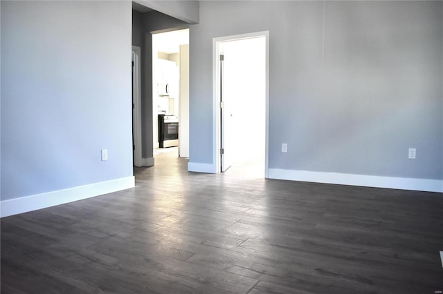 empty room with dark wood finished floors and baseboards