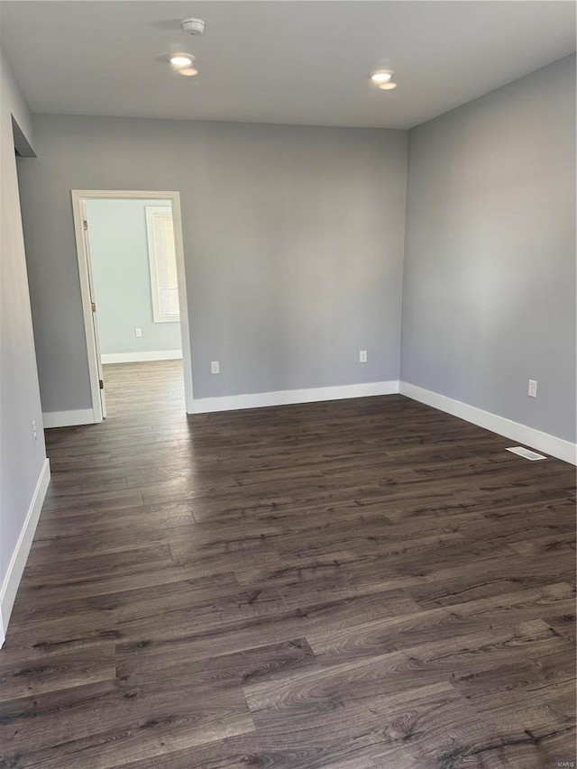 unfurnished room with visible vents, baseboards, dark wood-style flooring, and recessed lighting