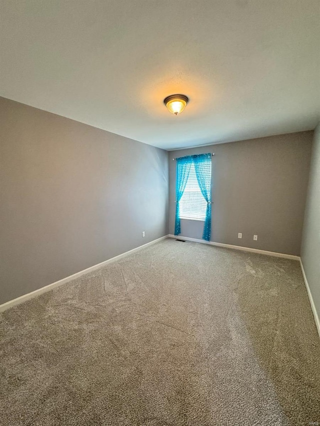 carpeted empty room with baseboards