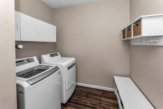 laundry room featuring cabinet space, baseboards, dark wood-type flooring, and washer and dryer