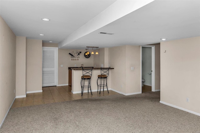 kitchen featuring carpet floors, recessed lighting, visible vents, baseboards, and tile patterned floors