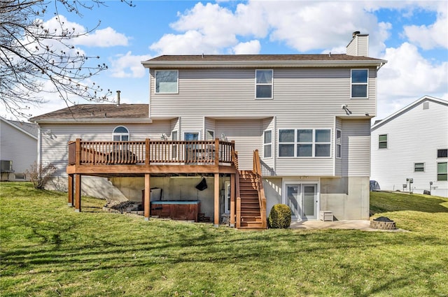 rear view of house featuring stairs, a chimney, a deck, and a yard