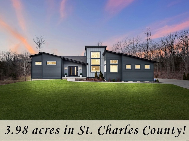 contemporary house featuring board and batten siding and a front lawn