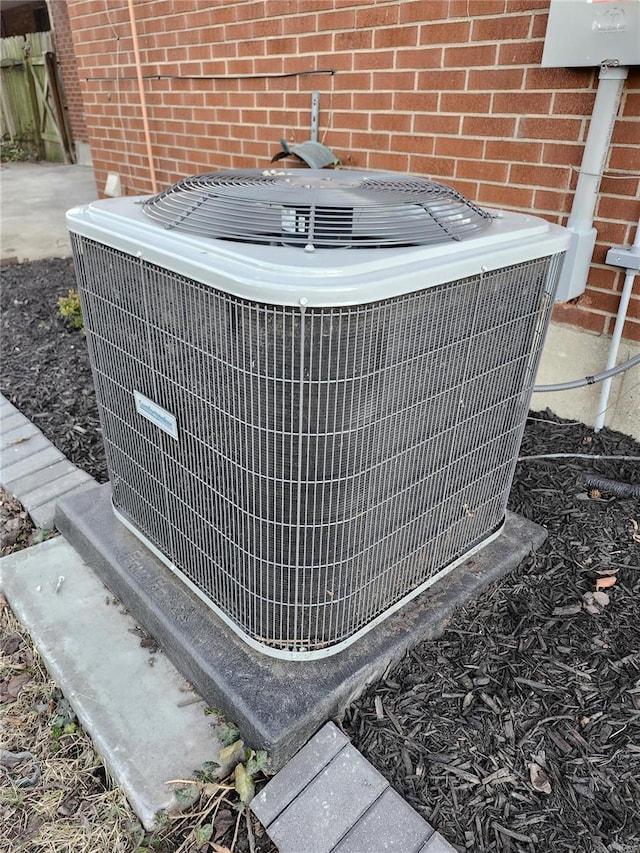 details featuring central AC unit and brick siding