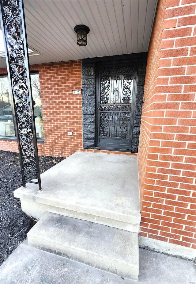 property entrance featuring brick siding