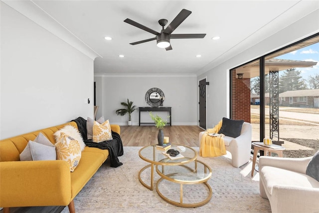 living area featuring baseboards, recessed lighting, wood finished floors, and crown molding