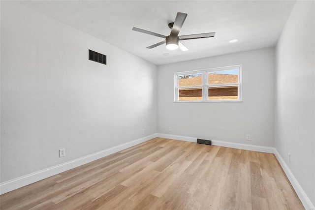 unfurnished room with ceiling fan, light wood-style flooring, visible vents, and baseboards