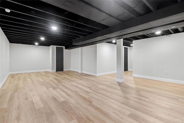 finished below grade area featuring light wood-style floors and baseboards