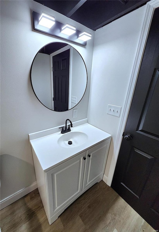 bathroom featuring baseboards, wood finished floors, and vanity