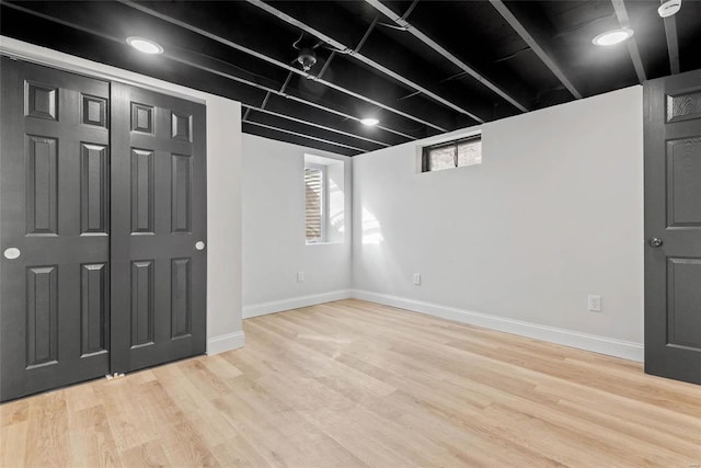 below grade area featuring light wood-style floors and baseboards