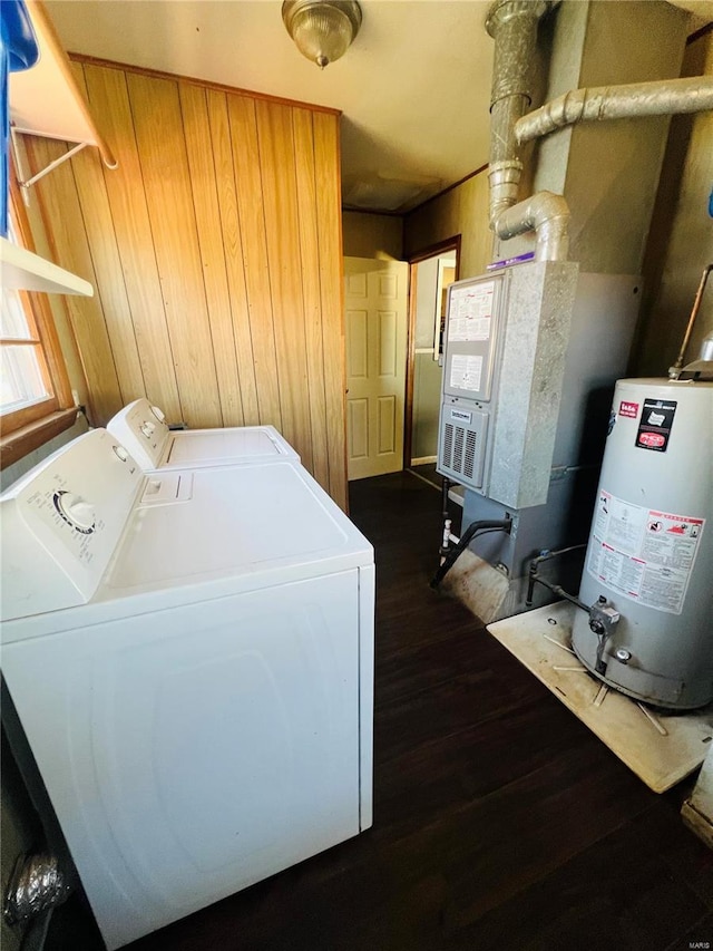 clothes washing area featuring laundry area, dark wood-type flooring, separate washer and dryer, and gas water heater