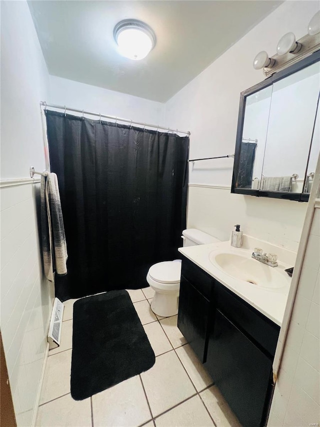 bathroom with toilet, a shower with curtain, vanity, and tile patterned floors