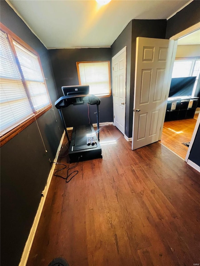 workout area featuring baseboards and wood finished floors