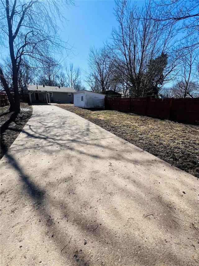 exterior space featuring concrete driveway and fence