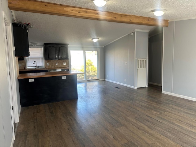 kitchen with open floor plan, dark wood-type flooring, a textured ceiling, and decorative backsplash