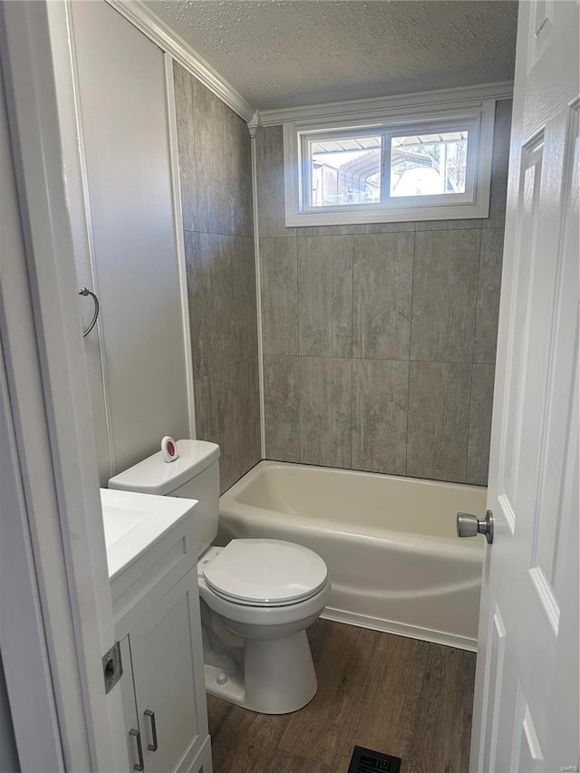 full bathroom featuring a textured ceiling, toilet, shower / bath combination, wood finished floors, and vanity