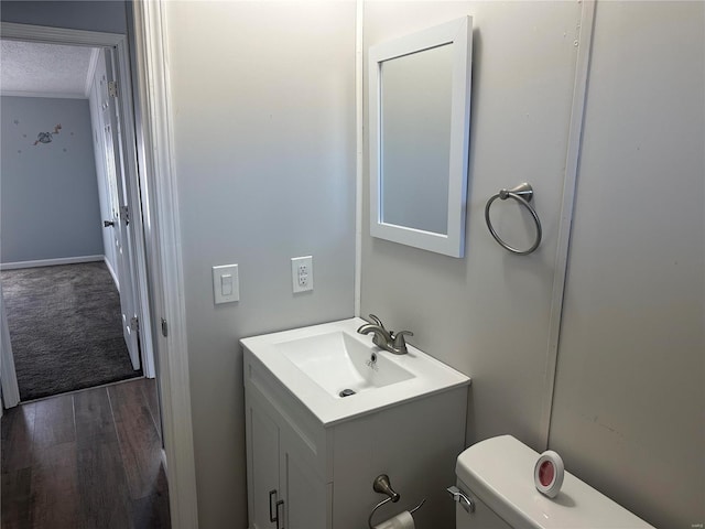 bathroom featuring toilet, vanity, a textured ceiling, and wood finished floors