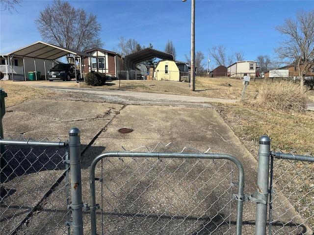 view of yard with driveway, fence, and a carport