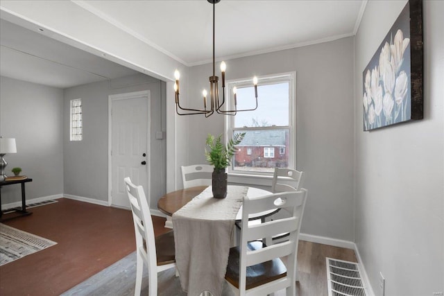 dining room featuring baseboards, visible vents, a chandelier, and wood finished floors