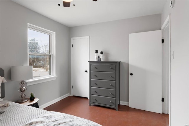 bedroom with finished concrete floors and baseboards