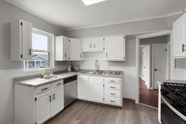 kitchen featuring light countertops, light wood-style flooring, stainless steel dishwasher, white cabinets, and a sink