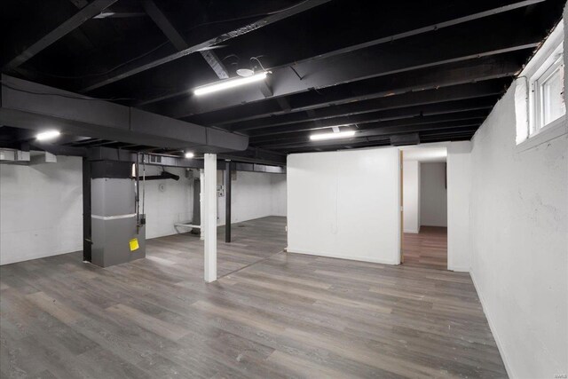 basement with heating unit and wood finished floors