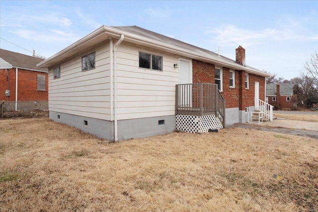 view of front facade featuring crawl space, a front yard, a chimney, and entry steps