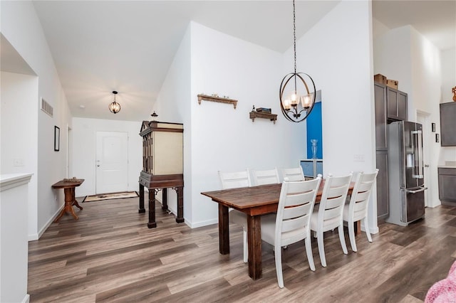 dining space featuring high vaulted ceiling, wood finished floors, visible vents, baseboards, and an inviting chandelier